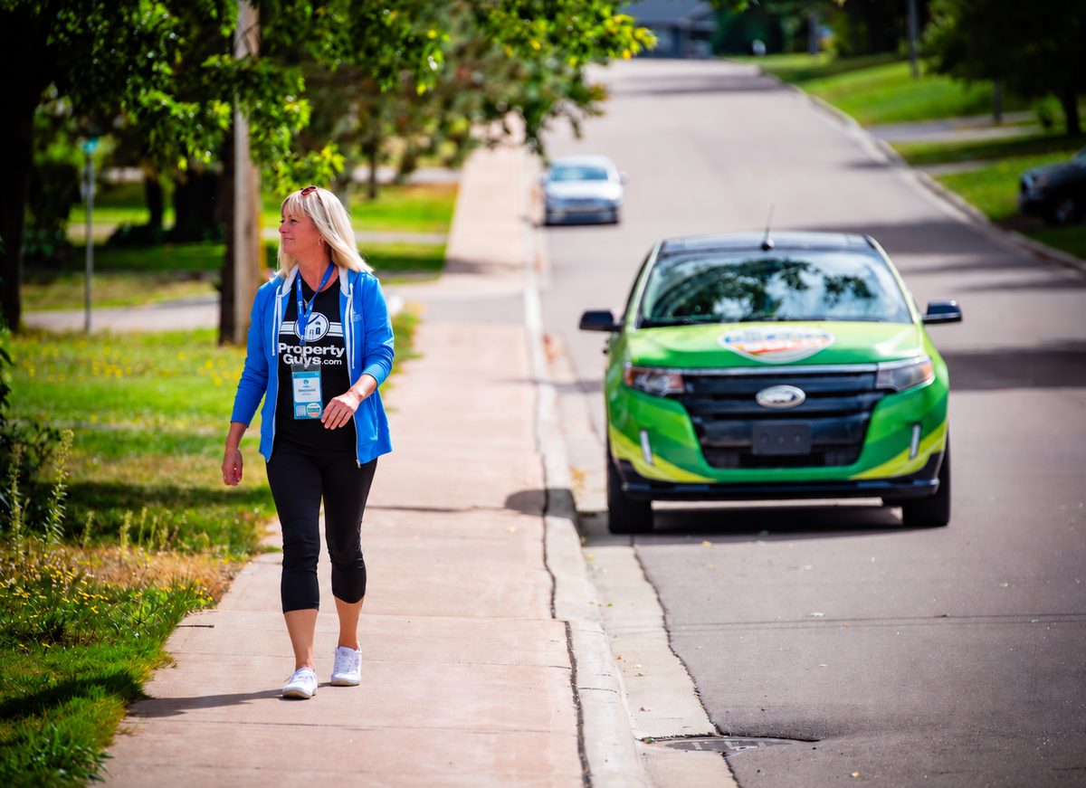 PropertyGuys.com franchisee Rhonda going door-to-door on a Wrap Walk